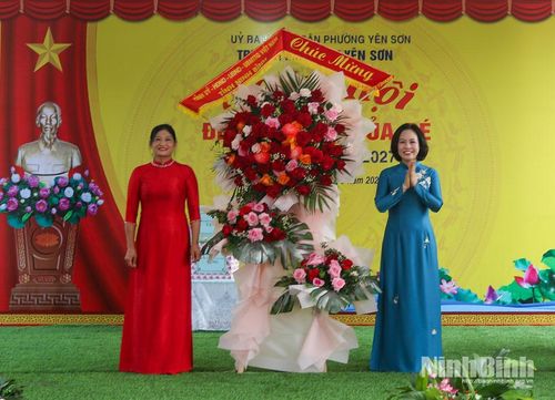 Đồng chí Trần Thị Hồng Thanh, Tỉnh ủy viên, Phó Trưởng đoàn đại biểu Quốc hội tỉnh tặng hoa chúc mừng Trường Mầm non Yên Sơn tại lễ khai giảng. Ảnh: Mai Phương