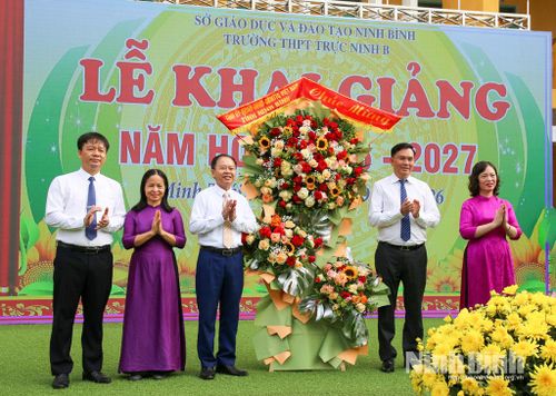 Đồng chí Đại tá Cù Quốc Thắng, Ủy viên Ban Thường vụ Tỉnh ủy, Giám đốc Công an tỉnh cùng các đại biểu trao tặng hoa chúc mừng nhà trường nhân dịp năm học mới. Ảnh: Nguyễn Hương