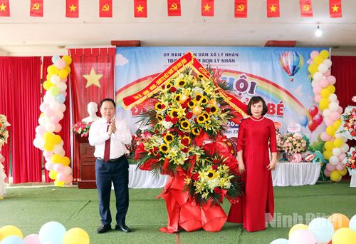 Đồng chí Vũ Hồng Hiên, Uỷ viên Ban Thường vụ Tỉnh uỷ, Chủ nhiệm Uỷ ban Kiểm tra Tỉnh uỷ tặng hoa chúc mừng cô và trò Trường Mầm non xã Lý Nhân. Ảnh: Trần Ích