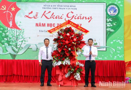 Đồng chí Nguyễn Hoàng Hà, Ủy viên Ban Thường vụ Tỉnh ủy, Phó Chủ tịch Thường trực Ủy ban Mặt trận Tổ quốc Việt Nam tỉnh tặng hoa chúc mừng lãnh đạo, giáo viên, học sinh Trường THPT Phạm Văn Nghị nhân dịp khai giảng năm học mới. Ảnh: Lam Hồng