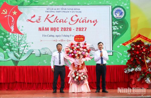 Lãnh đạo xã Yên Cường tặng hoa chúc mừng nhà trường. Ảnh: Lam Hồng