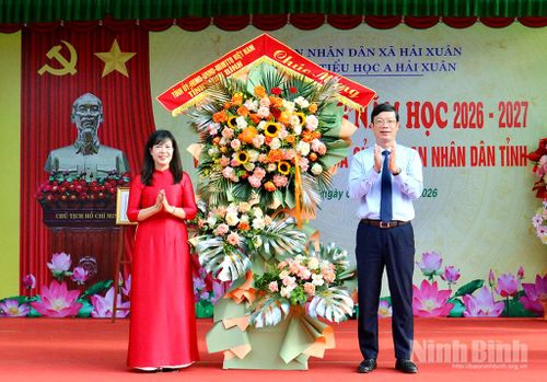 Đồng chí Nguyễn Minh Tiến, Uỷ viên Ban Thường vụ Tỉnh uỷ, Trưởng Ban Nội chính Tỉnh uỷ tặng hoa chúc mừng Trường Tiểu học A Hải Xuân. Ảnh: Khánh Dũng