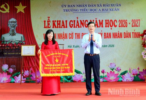 Đồng chí Nguyễn Minh Tiến, Uỷ viên Ban Thường vụ Tỉnh uỷ, Trưởng Ban Nội chính Tỉnh uỷ trao Cờ thi đua cho tập thể cán bộ, giáo viên, học sinh Trường Tiểu học A Hải Xuân. Ảnh: Khánh Dũng