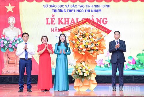 Đồng chí Trần Song Tùng, Ủy viên Ban Thường vụ Tỉnh ủy, Phó Chủ tịch Thường trực UBND tỉnh tặng hoa chúc mừng nhà trường nhân ngày khai giảng. Ảnh: Trường Giang