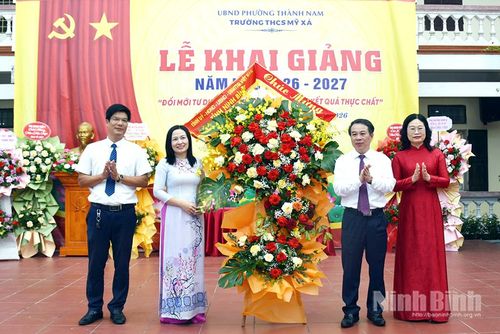 Đồng chí Bùi Hoàng Hà, Ủy viên Ban Thường vụ Tỉnh ủy, Phó Chủ tịch Thường trực HĐND tỉnh và đồng chí Vũ Thị Kim, Tỉnh ủy viên, Trưởng Ban Pháp chế, HĐND tỉnh tặng hoa chúc mừng thầy và trò Trường THCS Mỹ Xá, phường Thành Nam nhân dịp khai giảng năm học mới. Ảnh: Minh Tân