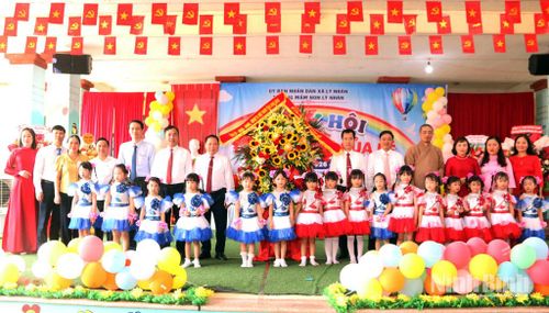 Các đại biểu chụp ảnh lưu niệm cùng cô và trò Trường Mầm non xã Lý Nhân. Ảnh: Trần Ích