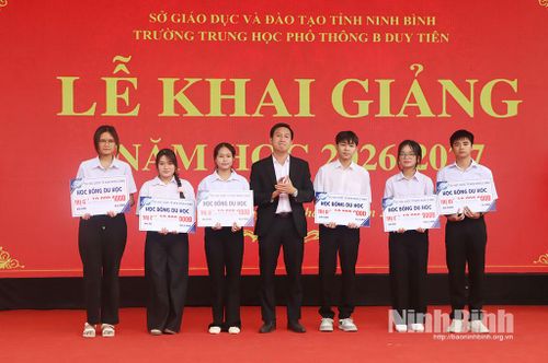 Đại diện Trung tâm du học trao tặng học bổng cho học sinh nhà trường. Ảnh: Phùng Thống