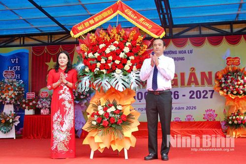 Lãnh đạo phường Hoa Lư tặng hoa chúc mừng Trường THCS Lý Tự Trọng. Ảnh: Minh Hải