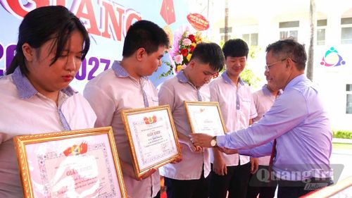 Đại diện lãnh đạo nhà trường trao giấy khen và phần thưởng cho 16 học sinh đạt thành tích cao trong học tập và rèn luyện năm học 2025-2026 - Ảnh: H.T