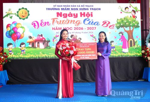 Đồng chí Phạm Thị Hân, Phó Chủ tịch Thường trực HĐND tỉnh tặng hoa và quà động viên cô và trò Trường mầm non Hưng Trạch - Ảnh: T.Đ
