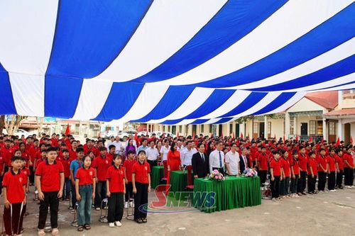 Các đại biểu và các em học sinh thực hiện nghi thức chào cờ.