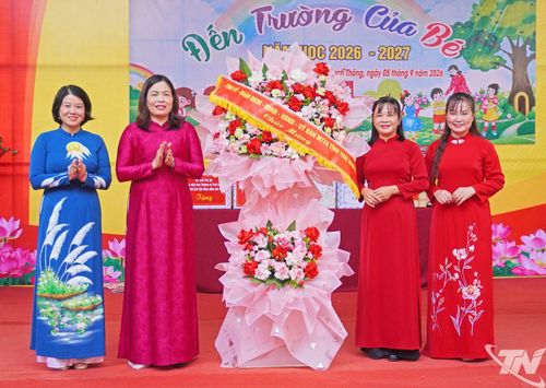 Đồng chí Trần Thị Lộc tặng hoa chúc mừng Trường Mầm non Bạch Thông.