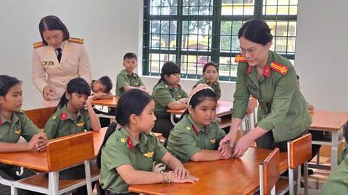 Trung tá Hải Yén và Trung tá Trần Vy Ly tận tình hướng dẫn, chăm sóc các em học sinh khối lớp 6 Trường Văn hoá CAND II trong ngày khai giảng năm học mới