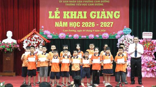 Ông Nguyễn Xuân Nhẫn, Chủ tịch UBND phường Cam Đường, trao quà cho các em học sinh có hoàn cảnh khó khăn.
