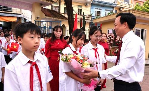 Chủ tịch UBND xã Tam Hưng Bùi Đình Thái tặng hoa chúc mừng và động viên học sinh lớp 6 Trường THCS Tam Hưng 1. Ảnh: Bình Minh