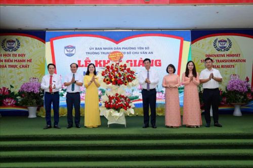 Bí thư Đảng ủy phường Yên Sở Nguyễn Minh Tâm cùng lãnh đạo phường tặng hoa chúc mừng thầy, trò Trường THCS Chu Văn An. Ảnh: Thái Phương