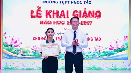 Bí thư Đảng ủy xã Hát Môn Nguyễn Đình Sơn tặng giấy khen cho học sinh Cấn Thùy Như, thủ khoa đầu vào Trường THPT Ngọc Tảo. Ảnh: HM