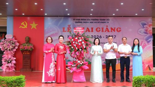 Lãnh đạo Phường Thanh Liệt tặng hoa chúc mừng thầy cô và học sinh Trường THCS Phạm Tu. Ảnh: PV