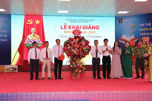 Đồng chí Nguyễn Quang Đường, Chủ tịch UBND xã Mỹ Đức (thứ năm từ phải qua) cùng đoàn công tác tặng hoa chúc mừng thầy trò Trường THPT Mỹ Đức A trong ngày khai giảng. Ảnh: Văn Biên