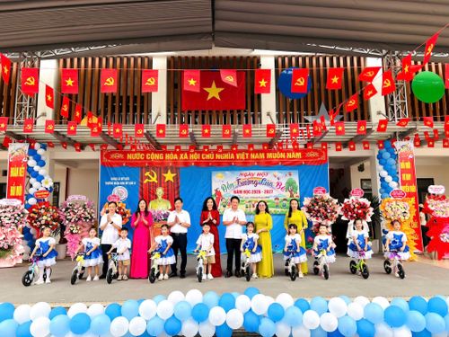 Các đồng chí lãnh đạo HĐND, MTTQ, Hội Chữ thập đỏ xã Mỹ Đức tặng xe đạp thăng bằng rèn thể chất cho các cháu trường Mầm non Mỹ Đức B. Ảnh: Văn Biên