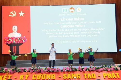 TS.BSCK2 Lâm Đức Hoàng – Trưởng khoa Xạ trị đầu mặt cổ, Bệnh viện Ung bướu TPHCM cùng các bệnh nhi ung thư biểu diễn tại lễ khai giảng lớp học Hoa Hướng Dương. Ảnh: BV cung cấp