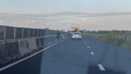Người đi bộ băng qua làn đường cao tốc Lộ Tẻ-Rạch Sỏi tiềm ẩn nguy cơ tai nạn giao thông. ( Ảnh: Thanh Dũng)