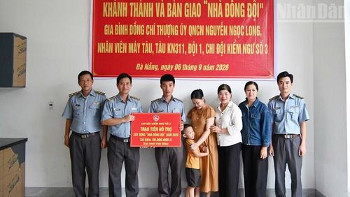 Đồng chí Vũ Thành Long, cán bộ Chi đội Kiểm ngư số 3 (thứ hai từ trái sang) trao kinh phí hỗ trợ nhà đồng đội cho gia đình đồng chí Nguyễn Ngọc Long. (Ảnh: NGUYỄN DŨNG)