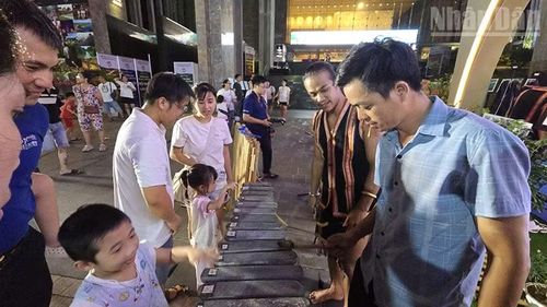 Du khách trải nghiệm đàn đá do nghệ sĩ dân tộc thiểu số tỉnh Gia Lai hướng dẫn. (Ảnh: PHÚC THẮNG)