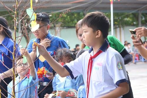 Các em học sinh treo mảnh giấy ghi ước mơ của mình lên “cây điều ước”