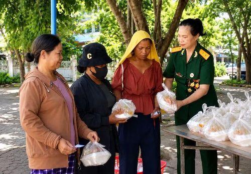 Bà Đinh Thị Lý (bìa phải) tặng cơm cho bệnh nhân và người nhà bệnh nhân có hoàn cảnh khó khăn tại Trung tâm Y tế Kbang. Ảnh: NVCC