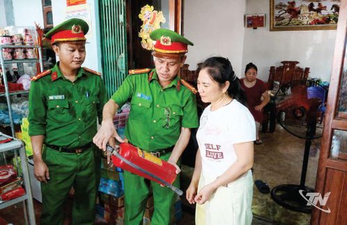 Công an phường Trung Thành hướng dẫn người dân sử dụngbình chữa cháy.