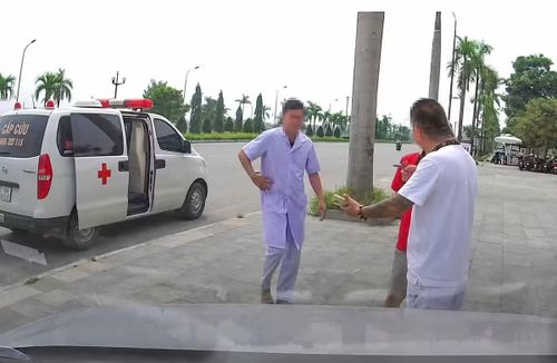 Hình ảnh người đàn ông mặc áo blouse trắng đi cùng xe cấp cứu, đưa bệnh nhân về nhà. Ảnh cắt từ clip.