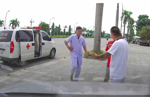 Hình ảnh người đàn ông mặc áo blouse trắng đi cùng xe cấp cứu, đưa bệnh nhân về nhà. Ảnh cắt từ clip.