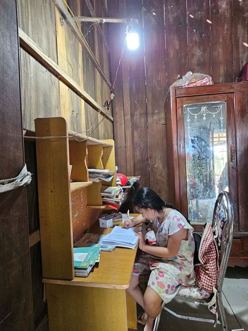 Bé Ngọc Hân con gái chị Loan ngồi học bài với ánh đèn từ điện năng lượng. Ảnh: Hòa Hội.