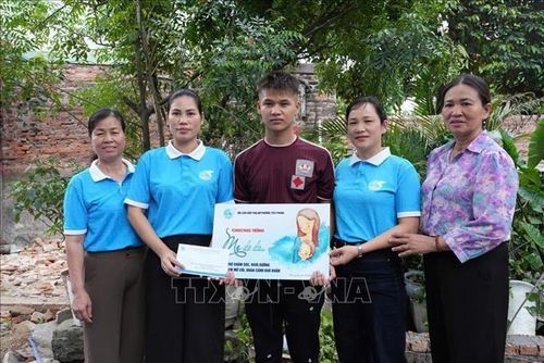 Phụ nữ Bắc Ninh trao hỗ trợ chương trình "Mẹ đỡ đầu" cho các học sinh có hoàn cảnh khó khăn. Ảnh: TTXVN phát