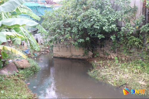 Một công trình phụ được xây dựng choán một nửa bề rộng lòng mương, làm co hẹp dòng chảy và ảnh hưởng thoát nước xuống hạ lưu. Ảnh: HOÀNG HIỆP
