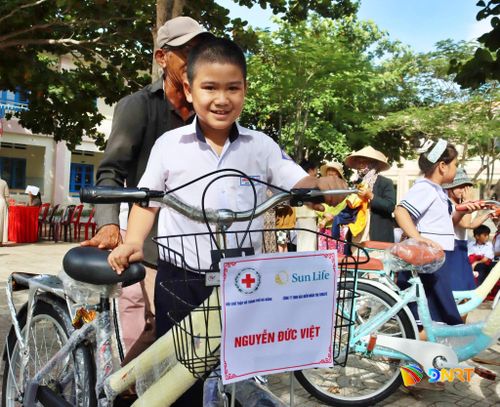 Em Nguyễn Đức Việt, học sinh Trường Tiểu học Junko phân hiệu 2 vui mừng bên chiếc xe đạp mới. Ảnh: XUÂN SƠN