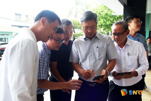 Phó Chủ tịch UBND thành phố Hồ Quang Bửu (thứ 4, từ trái sang) trải nghiệm tải và sử dụng app OneCare. Ảnh: TRỌNG HUY