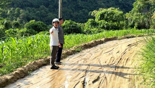 Nước mưa cuốn đất, cát tràn xuống mặt đường vào thôn Nậm Đét, gây khó khăn cho việc đi lại.