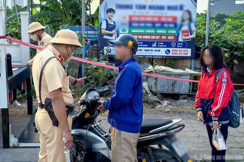 Một trường hợp phụ huynh chở học sinh ngồi trên xe máy không đội mũ bảo hiểm đi học.