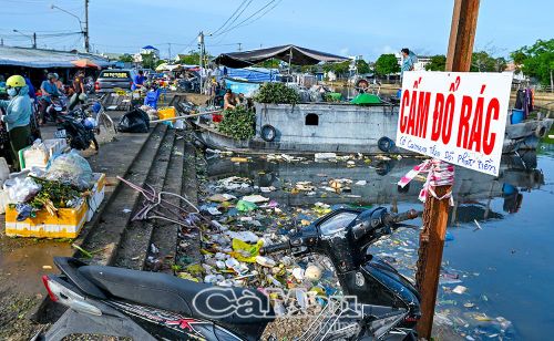 Dù địa phương có gắn biển cấm đổ rác và cảnh báo có camera quan sát để xử lý vi phạm nhưng một bộ phận người dân thiếu ý thức vẫn vứt rác bừa bãi xuống sông. (Ảnh chụp tại khu vực ven bờ kè chợ Nông sản - Thực phẩm phường Tân Thành).