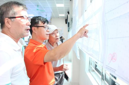 Ông Nguyễn Hữu Tính (áo cam) theo dõi quy hoạch khu dân cư truyền thống Thúy Lĩnh. Ảnh: MH
