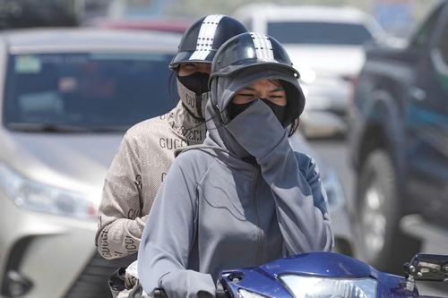 Nắng nóng và bụi buộc người dân phải trang bị 'kín cổng cao tường' khi lưu thông.