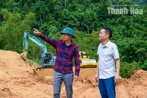 Chủ tịch UBND xã Sơn Điện Phạm Văn Tình (bên trái) chỉ đạo các đơn vị liên quan khẩn trương làm mặt bằng, bàn giao đất cho người dân xây dựng nhà ở kiên cố.