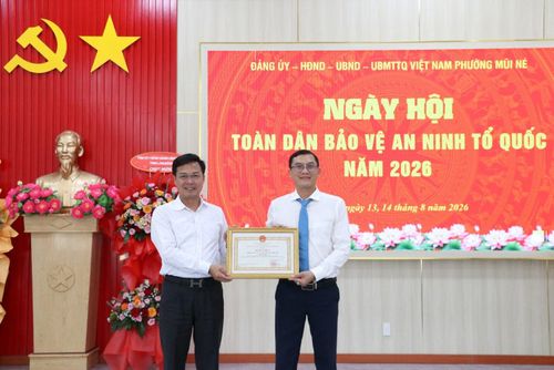Tỉnh ủy viên, Phó Chủ tịch UBND tỉnh Lâm Đồng Đinh Văn Tuấn (trái) trao Bằng khen của Chủ tịch UBND tỉnh cho cán bộ và Nhân dân phường Mũi Né vì có thành tích xuất sắc trong triển khai các hoạt động hưởng ứng Ngày hội toàn dân bảo vệ an ninh Tổ quốc năm 2026