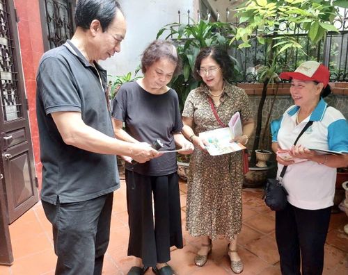 Các lực lượng tuyên truyền, phát tờ rơi hướng dẫn người dân thực hiện các biện pháp phòng, chống sốt xuất huyết tại hộ gia đình. Ảnh: H.Duy