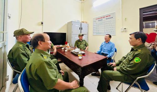 Ông Phạm Ngọc Quế (áo xanh), Trưởng ban Công tác Mặt trận Tổ dân phố số 13, trao đổi công việc với các thành viên Tổ An ninh cơ sở. Ảnh: Trần Oanh