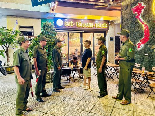 Các thành viên Tổ An ninh cơ sở nhắc nhở hộ kinh doanh chấp hành quy định về phòng cháy chữa cháy và vệ sinh môi trường. Ảnh: Trần Oanh