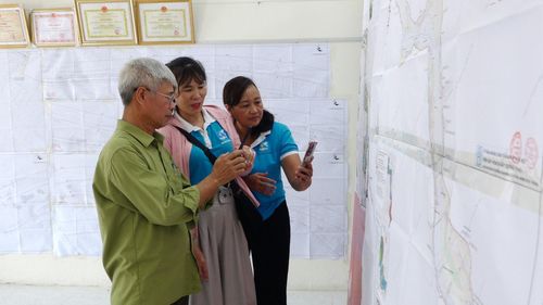 Người dân xã Ô Diên trực tiếp tìm hiểu bản đồ quy hoạch, trao đổi về phương án hướng tuyến và những nội dung liên quan đến khu vực mình sinh sống. Ảnh: Đỗ Duẩn