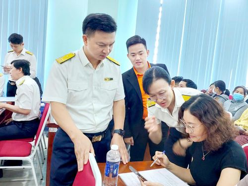 Cán bộ thuế hướng dẫn hộ kinh doanh đăng ký chuyển đổi sang thuế kê khai. Ảnh: MAI HOA